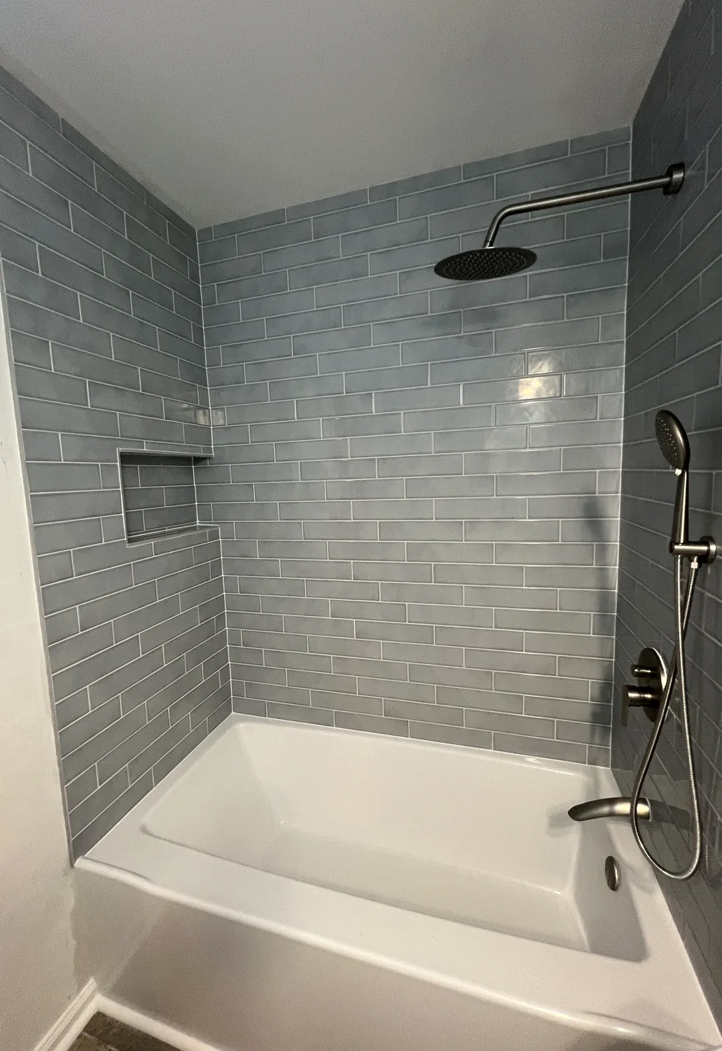 Gray subway tile shower installation in Charlotte NC with built in shower niche
